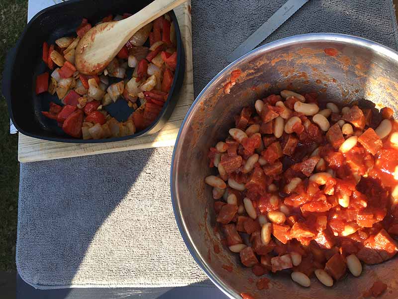 Add garlic and spices, cook for another minute, then add to the tomatoes, beans, chorizo sausage, stirring carefully so that the beans do not break up.